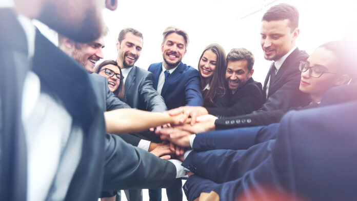 Large,Business,Team,Showing,Unity,With,Their,Hands,Together