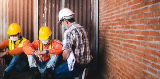 Economy Healing But Workers Are Not Supervisors and construction workers sit sad at the job site.