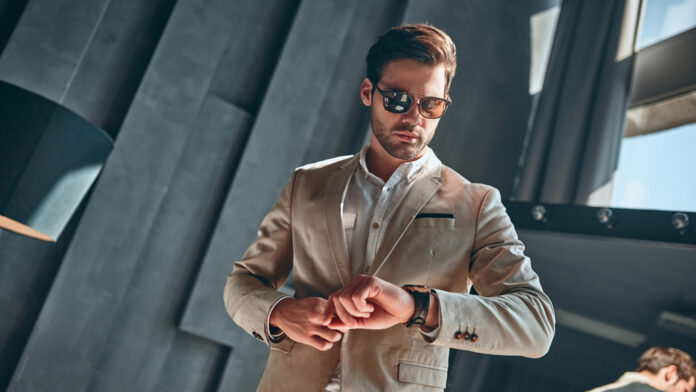 Handsome,Stylish,Man,In,Beige,Suit,At,Home,Checking,Time.