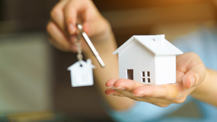 Woman,Holding,White,House,Model,And,House,Key,In,Hand.mortgage