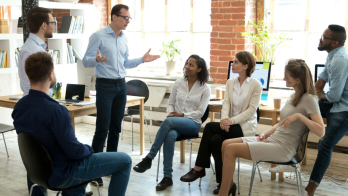 Diverse,Business,Team,Employees,Listening,To,Male,Manager,Coach,Speaking