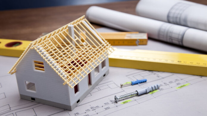 Construction,Plans,With,Helmet,And,Drawing,Tools,On,Blueprints