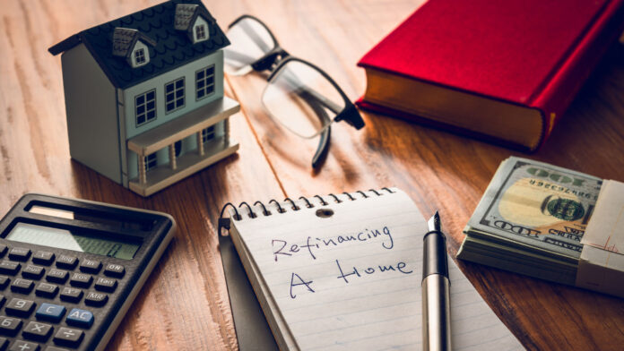 Refinancing,Words,On,Notebook,With,Us,Dollars,And,Stuff,On