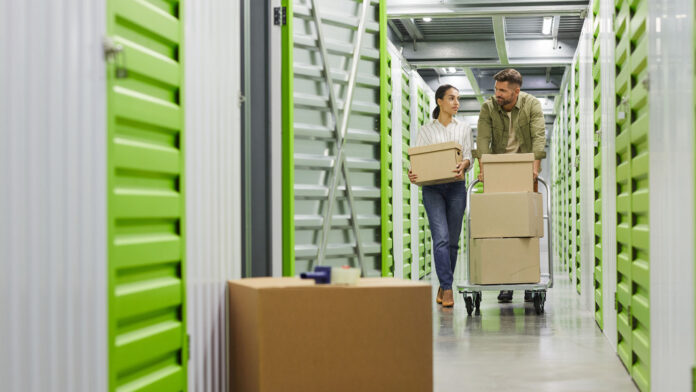 Full,Length,Portrait,Of,Young,Couple,Holding,Cardboard,Boxes,Walking
