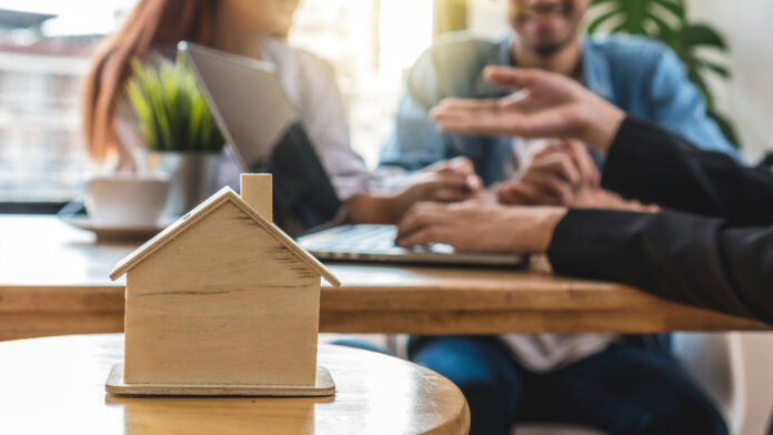 Closeup,House,Model,Over,The,Sale,Representative,Offer,The,Price