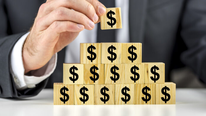 Closeup,Of,Businessman,Making,A,Pyramid,Of,Wooden,Cubes,With