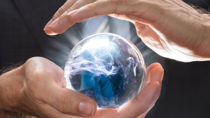 Midsection,Of,Businessman,Covering,Crystal,Ball,With,Swirling,Smoke,At