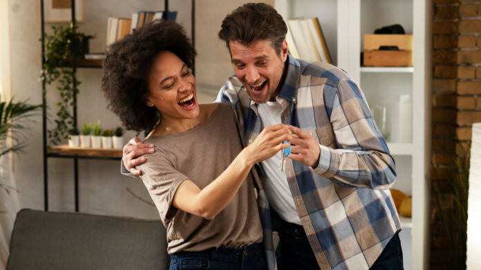 Smiling,Couple,Is,Taking,Keys,From,Their,New,Apartment.,Husband