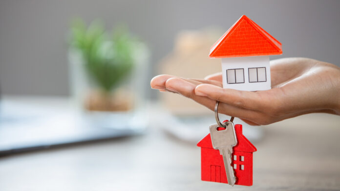 Real,Estate,Agents,Hold,House,Keys,And,Have,Houses,Placed