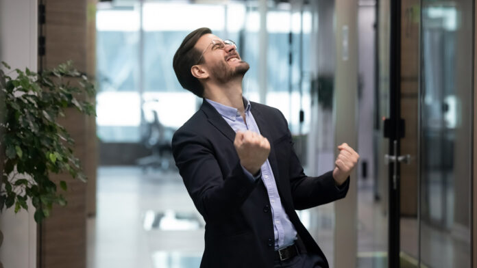 Millennial,Office,Worker,In,Suit,Standing,In,Hallway,Clenched,Fists