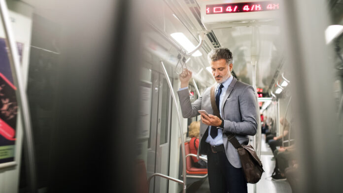 Mature,Businessman,With,Smartphone,In,A,Metro,Train.