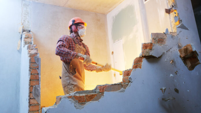 Worker,With,Sledgehammer,At,Indoor,Wall,Destroying