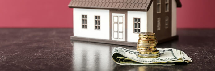 Figure of house and money on table. Concept of buying real estat